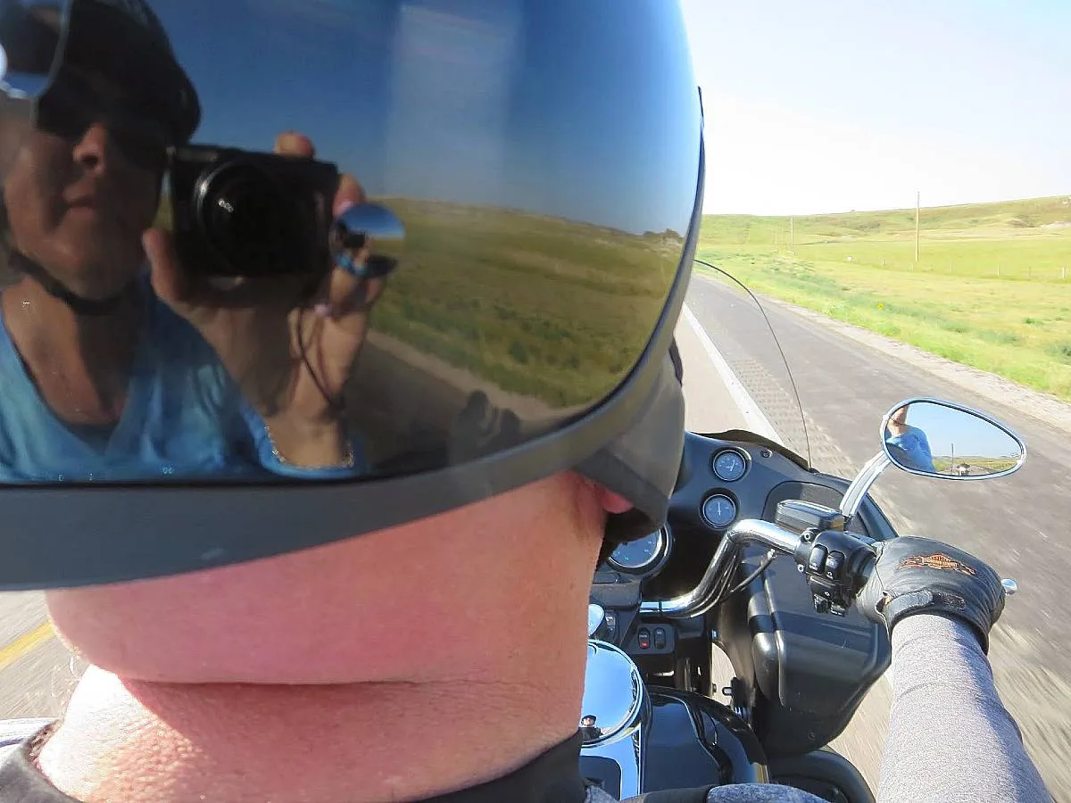 A fun one-handed shot I took while riding on the back of our motorcycle and capturing the reflection of myself in hubby's helmet.